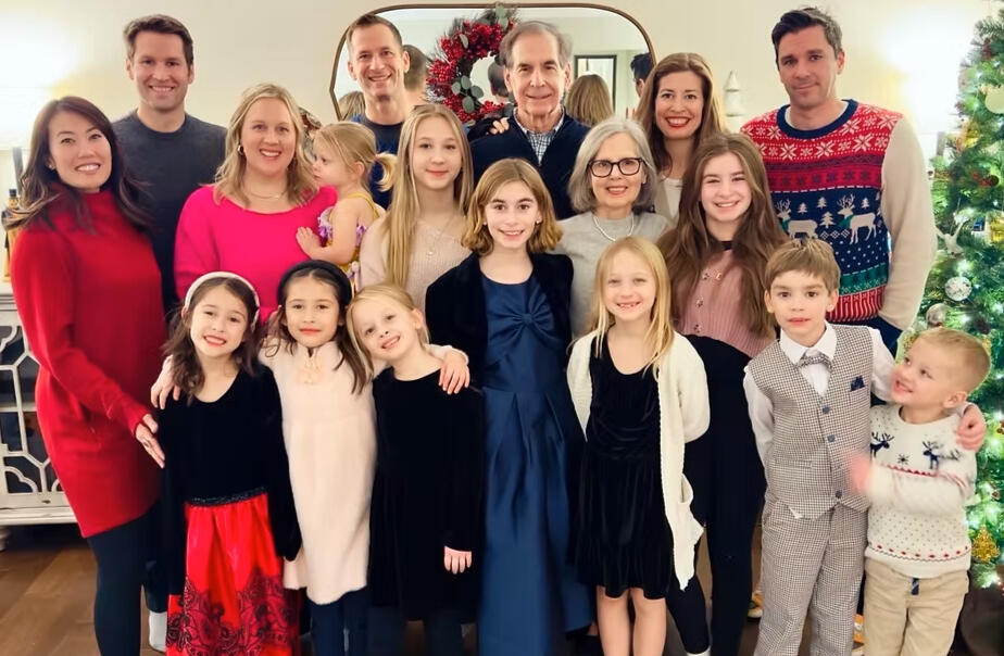 Jan posing for picture with family surrounding him